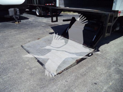 Freightliner M2 106 rear cargo area and auxiliary ramp in loading position showing scale platform with metal surface.