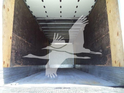 Cargo trailer interior showing empty box with wooden side walls and metal floor. No visible text on walls or floor.