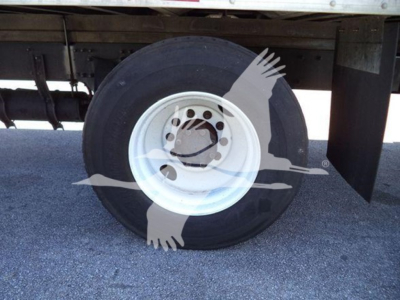 Wheel of a Freightliner M2 106 truck showing white steel rim and tire under cargo area.