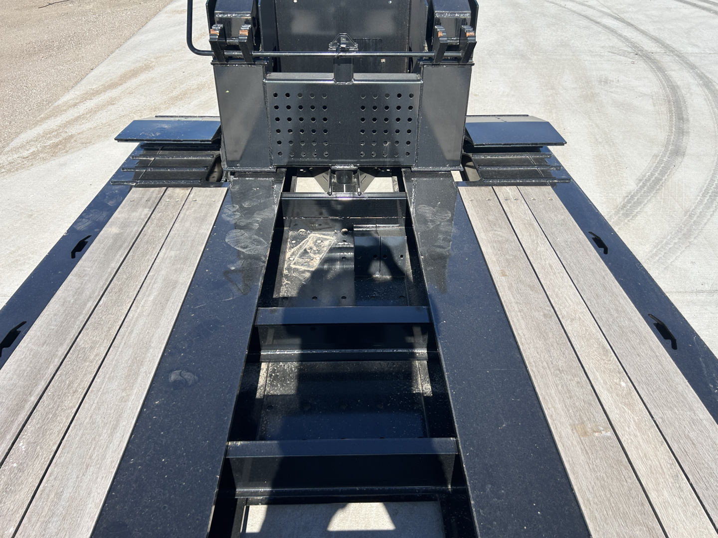 Trailer deck showing Load King royal blue platform with walkable steel ramps and central ballast area, top of rear cab visible.