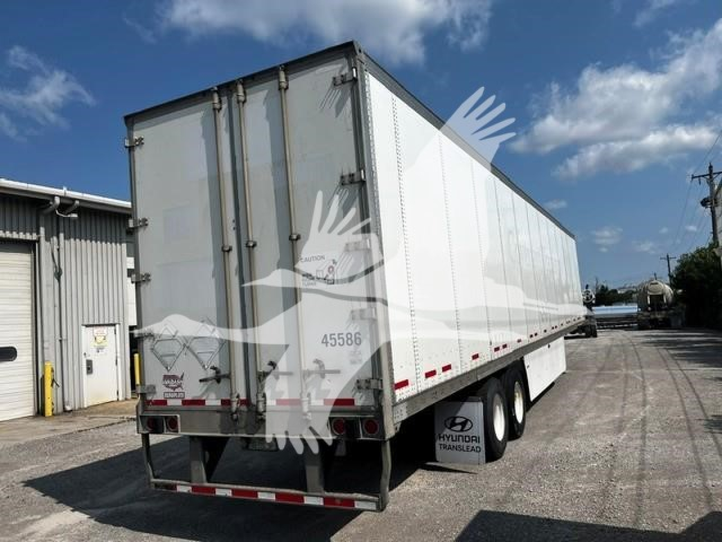 Rear and side view of a used 2017 Wabash trailer with white exterior, dual rear doors, and triple-axle set.