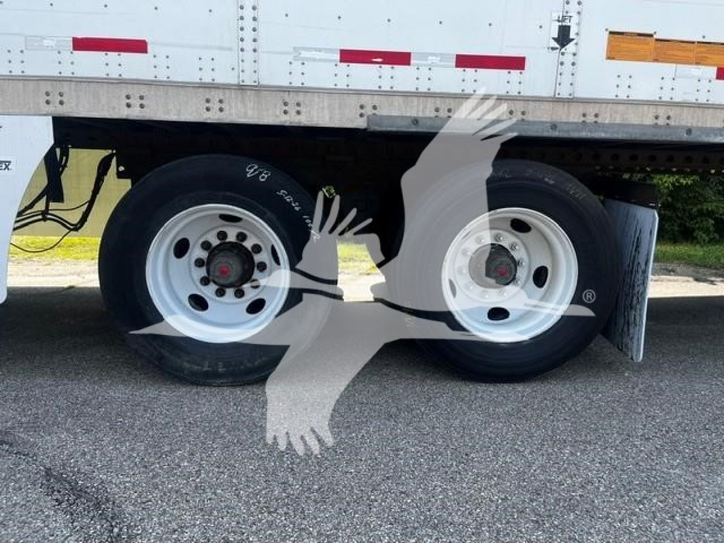 Trailer axle area of a 2017 Wabash van showing dual wheels, tires, and a portion of the trailer frame with reflective tape.