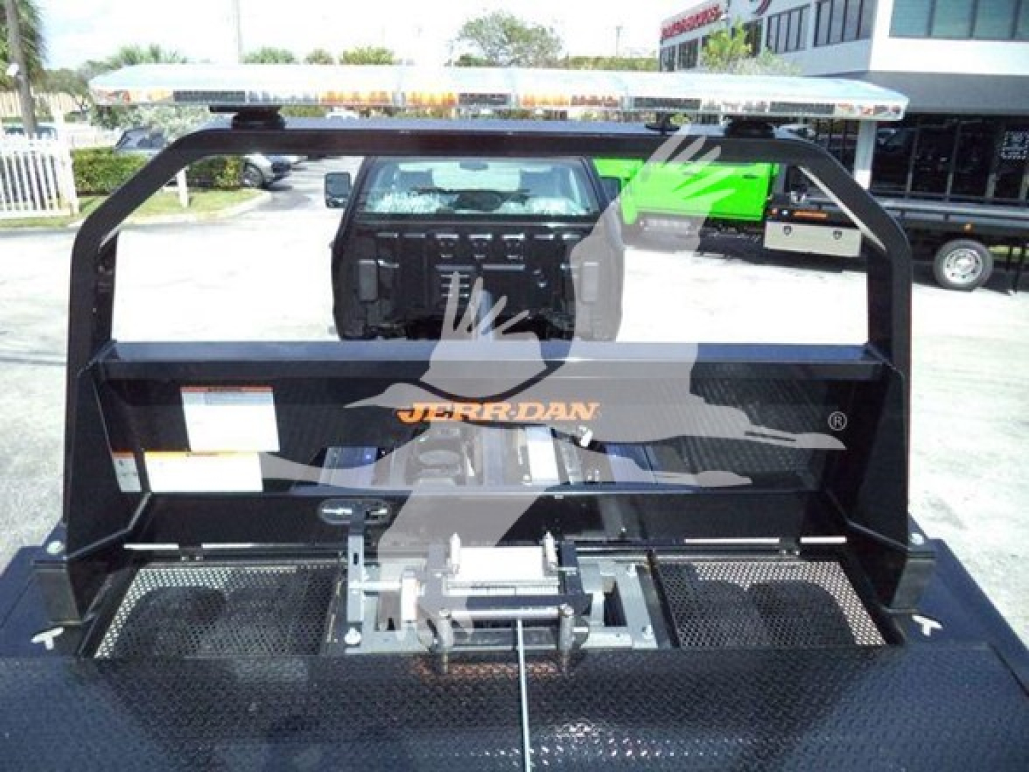Truck bed with gooseneck hitch and JERR-DALN branding in metal frame, chassis and platform visible.