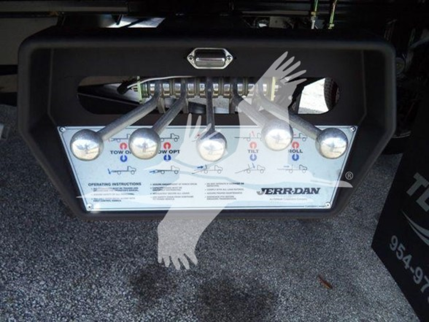 Trailer hitch assembly with control panel showing JERR-DAN branding and operating instructions, panel contains multiple toggles and warning icons.