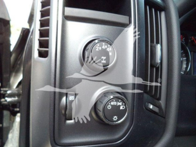 Trucks dashboard control panel showing headlight switch and four-wheel drive knob in view; circular knobs with icons for lights and drive modes.