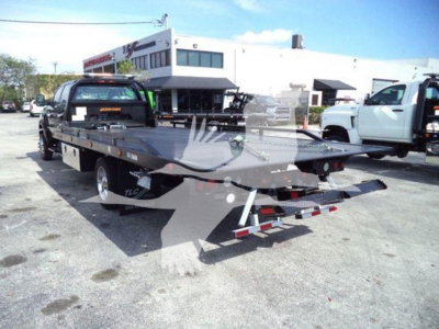 2023 International CV rollback truck with flatbed tow bed in an outdoor lot.