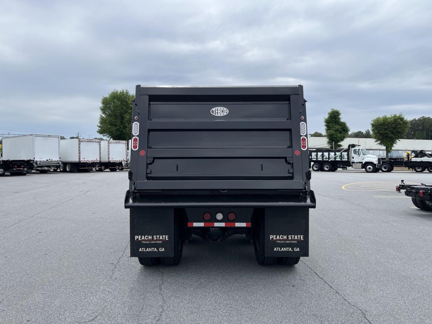 Western Star dump truck bed rear showing taillights and dirt-deflector mudflaps with Peach State Atlanta GA text.
