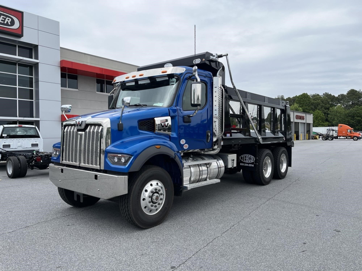 Western Star 47X dump truck in blue cab with black dump body, front chrome grille, large wheels, and Dana-style chassis, VIN visible in listing.