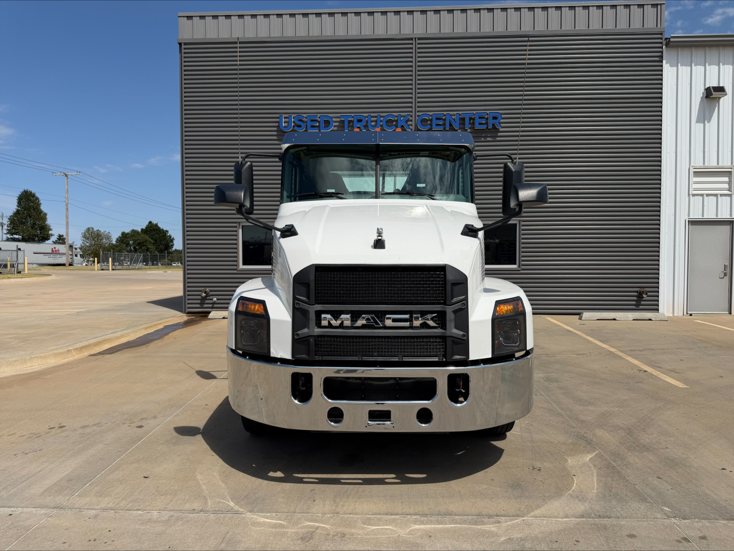 Front view of a 2020 Mack Anthem daycab truck parked outside a dealership building. Clear grille, bumper, headlights visible.