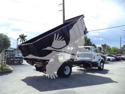 Dump truck in a dealership lot, white International Durastar 4300 with tilted bed raised for dumping. VIN 3HAMMMML7KL383647, stock T83647.