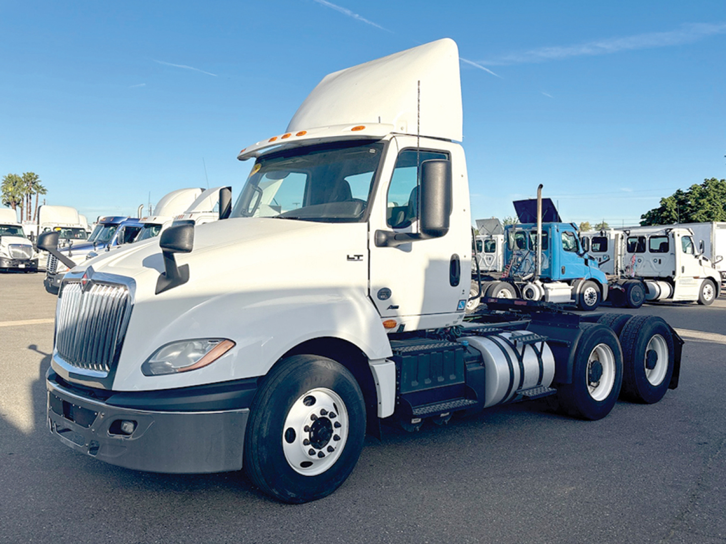2018 International LT625 conventional daycab tractor in white, side view, with sleeper cab raised roof, showing front grille, headlights, fuel tanks, and dual rear axles.