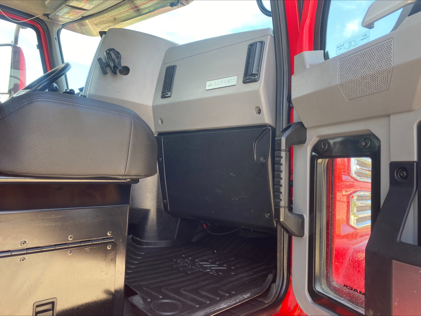Cab interior of a 2021 Mack Anthem truck showing the driver's seat, dashboard area, and open door threshold.