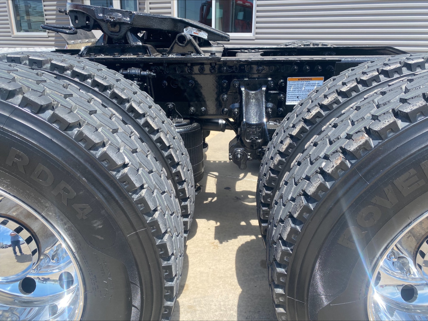 Trucks chassis showing dual rear axles with heavy-duty off-road tires and suspension components.