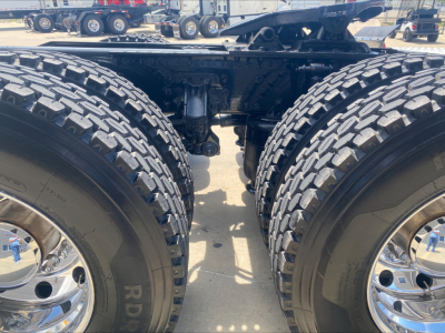 Dual rear axles of a 2021 Mack Anthem truck showing heavy-duty tires and chassis frame with wheel hubs.