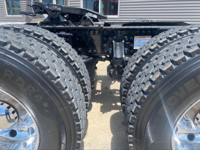 Trucks chassis showing dual rear axles with heavy-duty off-road tires and suspension components.