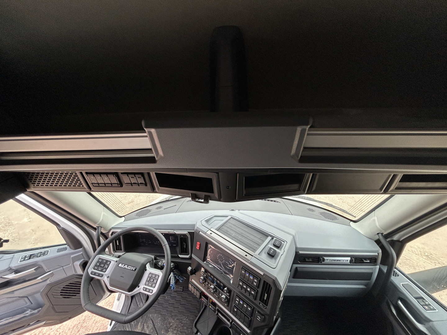 Truck cab interior view showing steering wheel and dashboard of a 2026 Mack PR64T44.