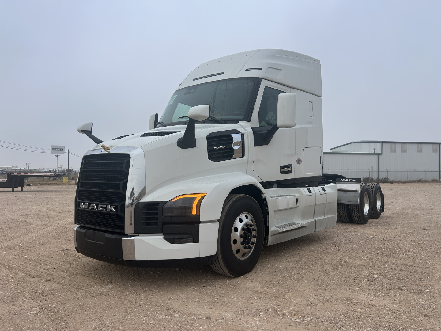 Mack PR64T44 conventional sleeper truck angled view showing front grille, headlights, and side mirrors.