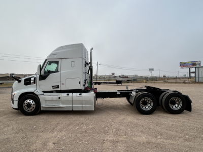 Truck chassis with cab in sleepered configuration, side view showing Mack PR64T44 chassis with dual rear axles and bare flatbed frame.