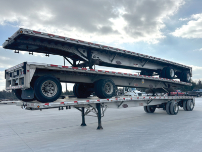 2009 Reitnouer aluminum flatbed trailer on a flatbed trailer with another trailer below; visible branding and structural components along sides.