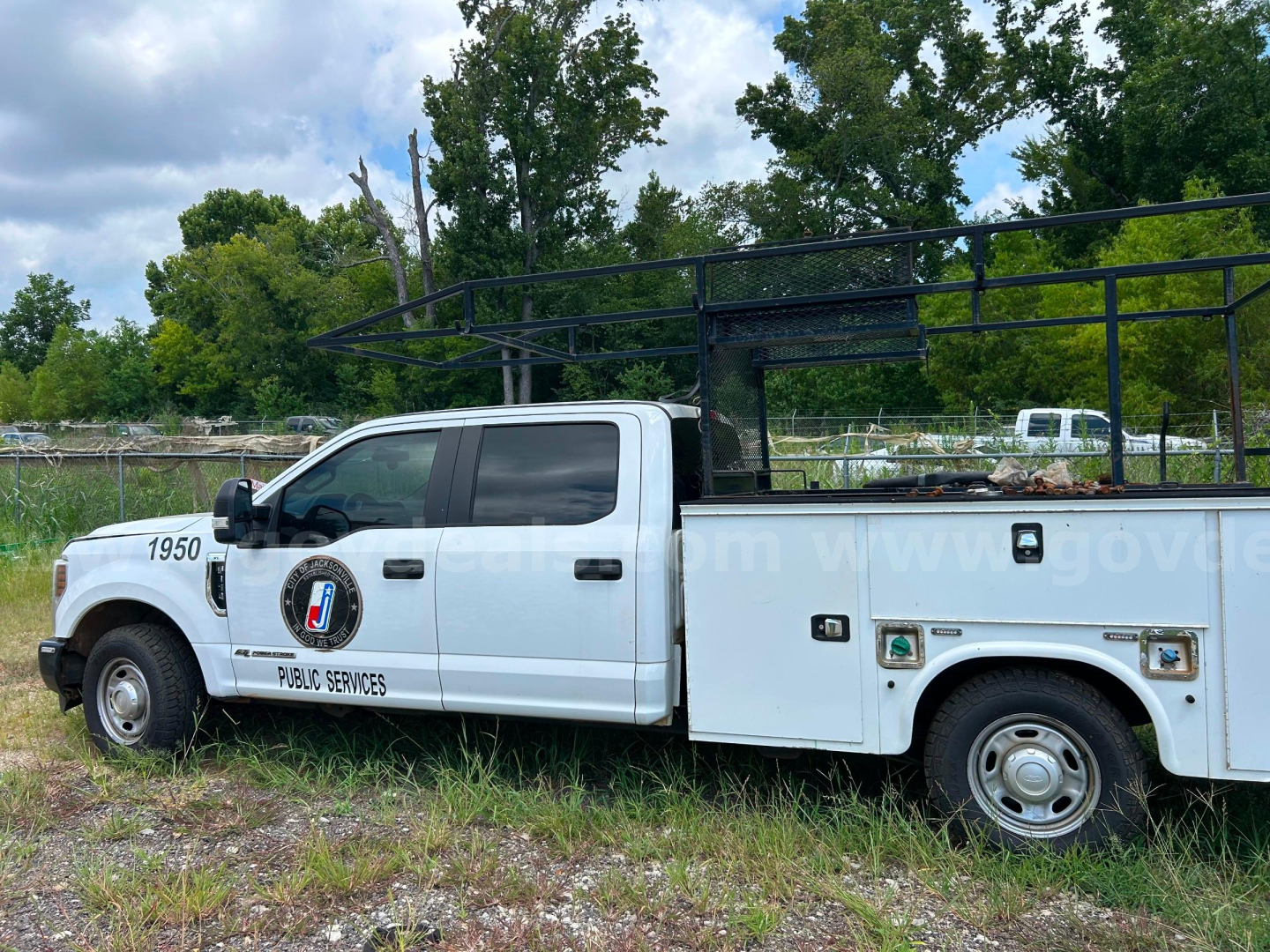 Ford F-350 service utility truck side view showing service body with compartments, 'PUBLIC SERVICES' emblem, and ladder rack. Visible text includes '1950' on front fender and generic stock information not shown.