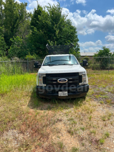 Ford F-350 service/utility truck front view with black grille, Ford emblem, ladder rack on roof, Texas license plate, and side mirrors.