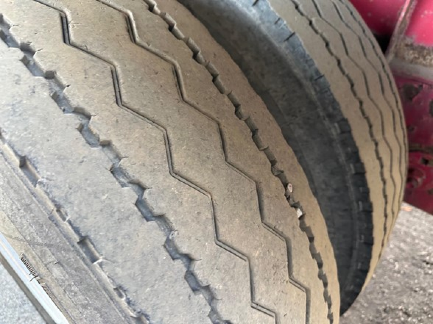 Suspension and dual tire setup on a Great Dane spread air combo flatbed trailer showing treaded tires with visible zigzag patterns.