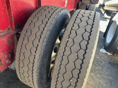 Two front tires of a Great Dane spread air combo flatbed trailer showing tread pattern and wheel rims.
