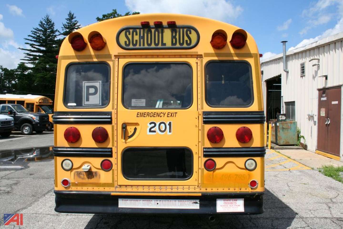 Rear view of a yellow 2002 GMC Savana bus with school bus markings, emergency exit, numbered 201, and parking sign window.