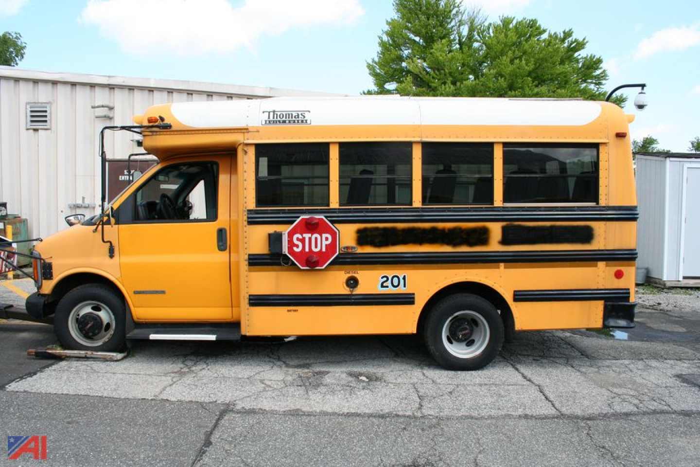 School bus in profile with STOP sign extended on the side and number 201, yellow body and black stripe, GMC Savana style bus.