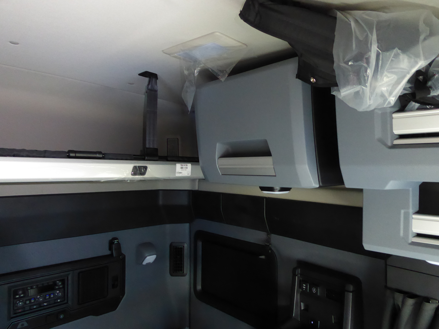 Cab interior of a 2026 Mack PR64T64 truck showing overhead sleeper area and control panels.