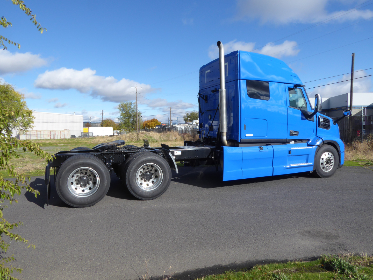 Blue 2026 Mack PR64T64 conventional sleeper truck chassis side view showing cab, exhaust stack, and dual rear axles.