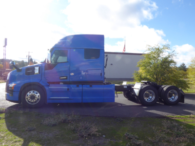 Truck cab and chassis of a 2026 Mack PR64T64 sleeping configuration showing blue exterior and attached trailer