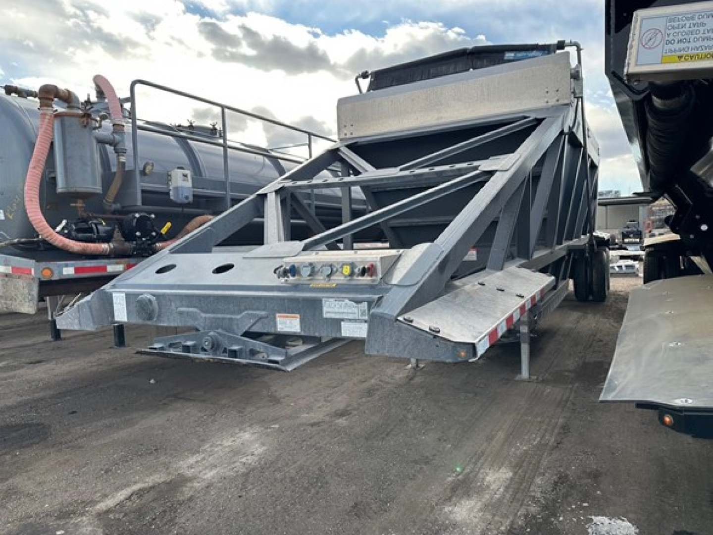 Dump trailer with air ride bottom dump mechanism showing structural frame and hydraulic components.