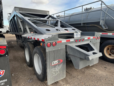 CPS bottom dump trailer showing side view with dual rear axles, mud flaps, and rear chassis with ladder-like frame. Visible CPS logo on mud flap and license plate 469735.