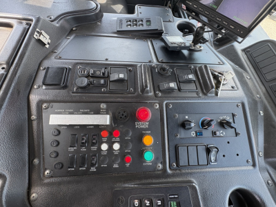 Cockpit/console panel of a 2019 Autocar XPEDITOR showing control switches, gauges, and a red emergency button with labels, and a small screen display.