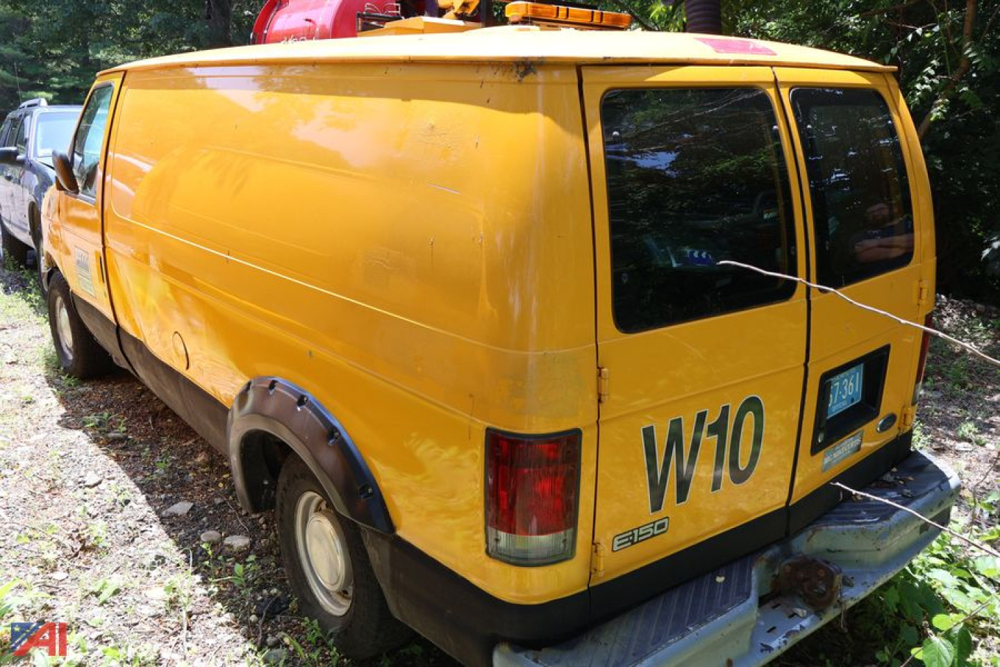 Yellow 2002 Ford E150 cargo van rear and side view showing W10 inscription and E150 badge.
