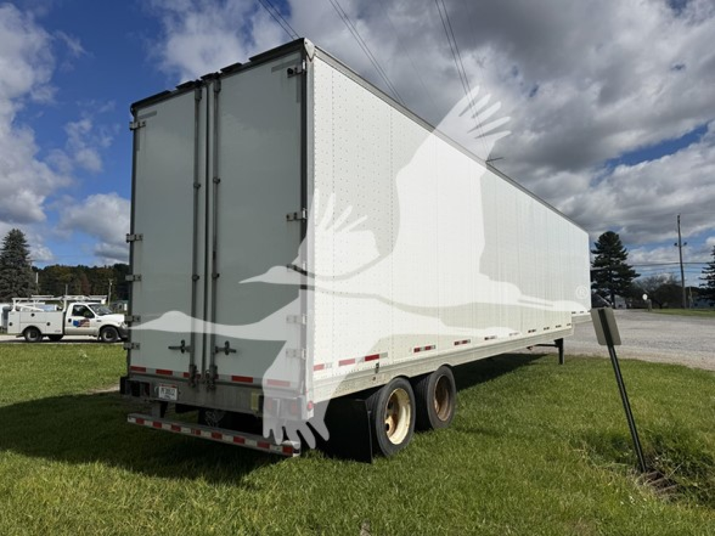 2015 Manac sheeted trailer with dual rear doors, white exterior, two-axle wheels, back view. Visible text not legible.