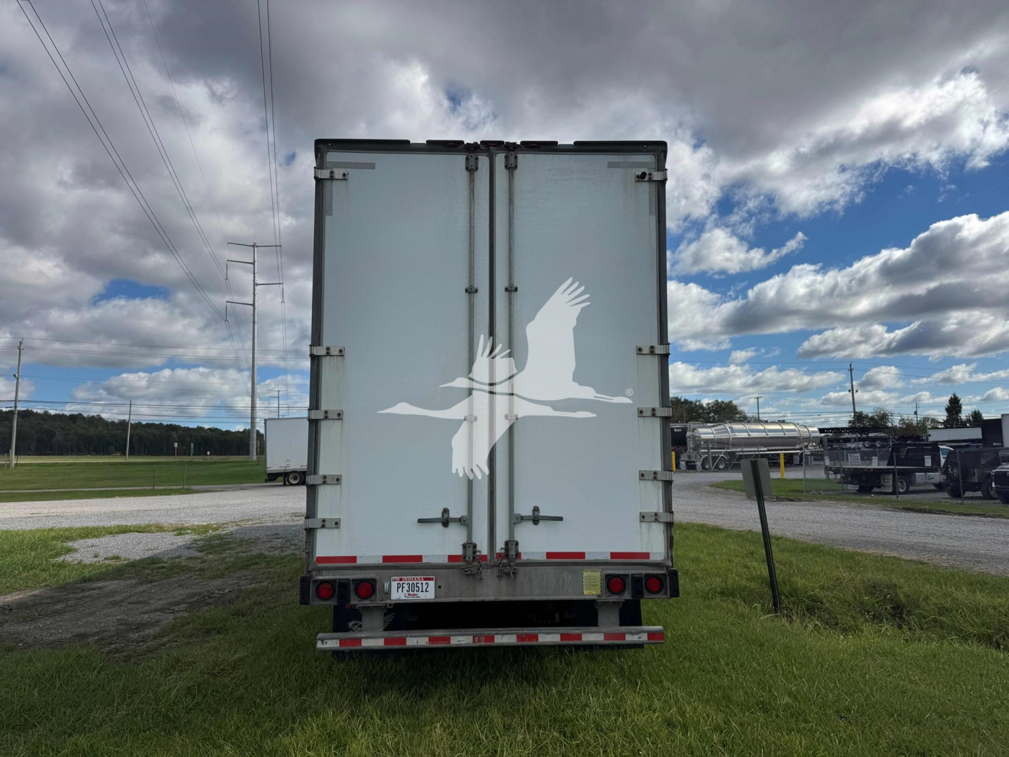 Manac drop van trailer rear view showing dual rear doors with hinges and latches, license plate area, and rear bumper with reflective tape.
