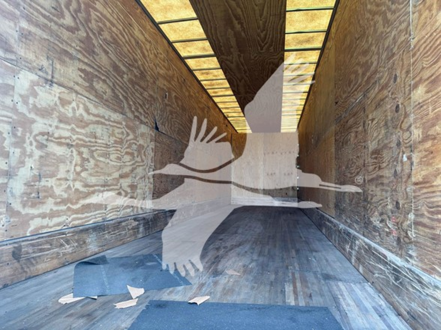 Manac sheet & post trailer interior showing wooden side walls and ribbed metal ceiling with light strips.