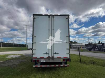 Manac drop van trailer rear view showing dual rear doors with hinges and latches, license plate area, and rear bumper with reflective tape.