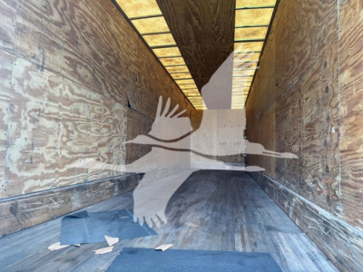 Manac sheet & post trailer interior showing wooden side walls and ribbed metal ceiling with light strips.