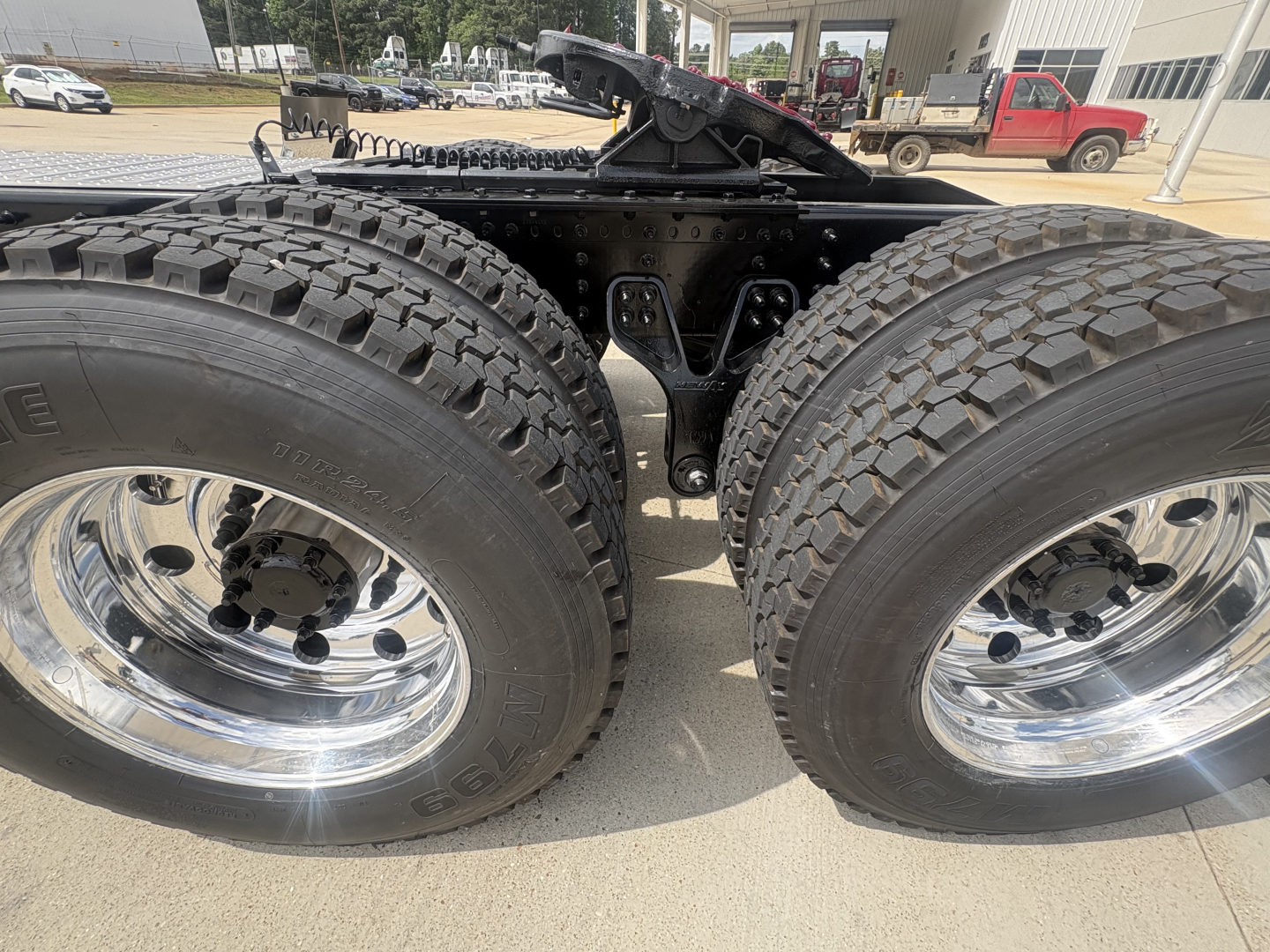 Dual rear wheel assembly of a new 2027 Mack PI64T tractor showing dual tired tires with chrome wheels and undercarriage frame.