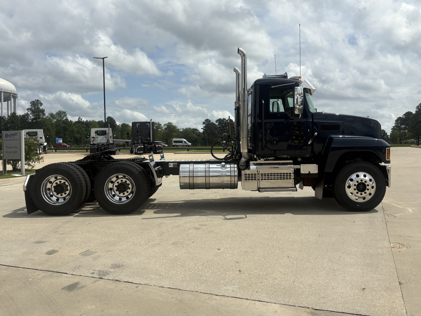 Mack PI64T truck chassis side view showing cab, exhaust stacks, fuel tanks, and dual rear axles.