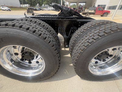 Dual rear wheel assembly of a new 2027 Mack PI64T tractor showing dual tired tires with chrome wheels and undercarriage frame.