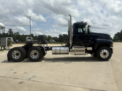 Mack PI64T truck chassis side view showing cab, exhaust stacks, fuel tanks, and dual rear axles.