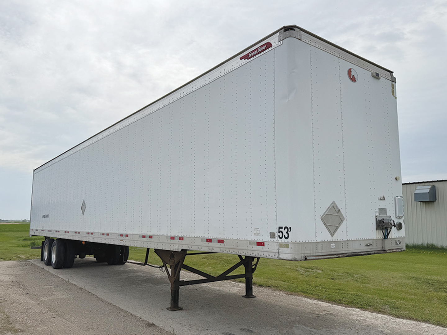Great Dane aluminum box trailer with 53 ft length, side reflection tape, rear ramps and landing gear visible.