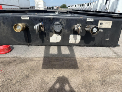 Trailer king back control panel showing pressure, return, and cap connections with labels and worn black metal surface.