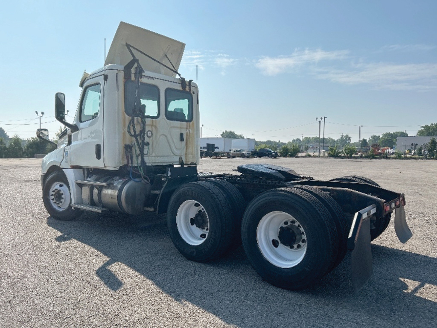 2019 Freightliner Cascadia126 truck in a gravel lot showing a daytime view of the cab and chassis with dual rear axles.