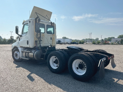 2019 Freightliner Cascadia126 truck in a gravel lot showing a daytime view of the cab and chassis with dual rear axles.
