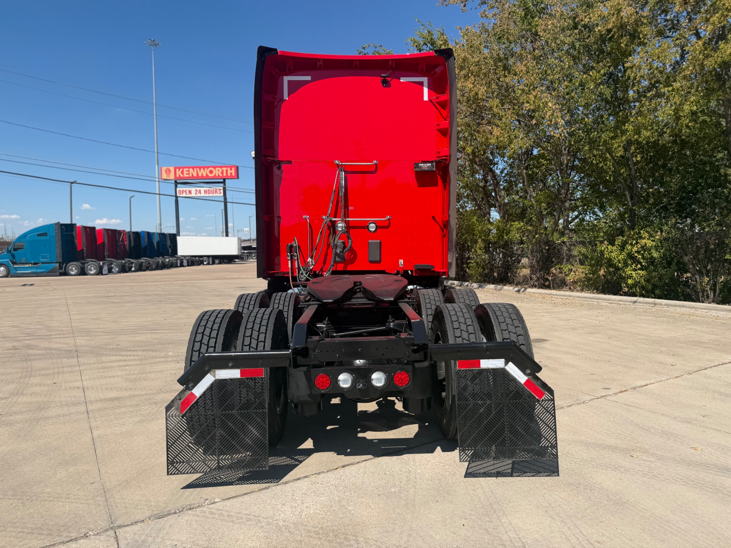 Kenworth T680 rear view showing dual rear fenders and bumper with mudflaps and lights.